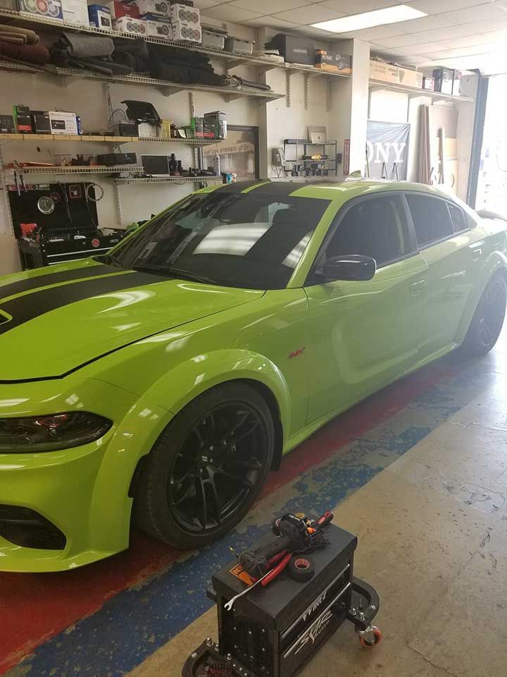 Exterior of "Radio Knob" building with a few cars parked in front.