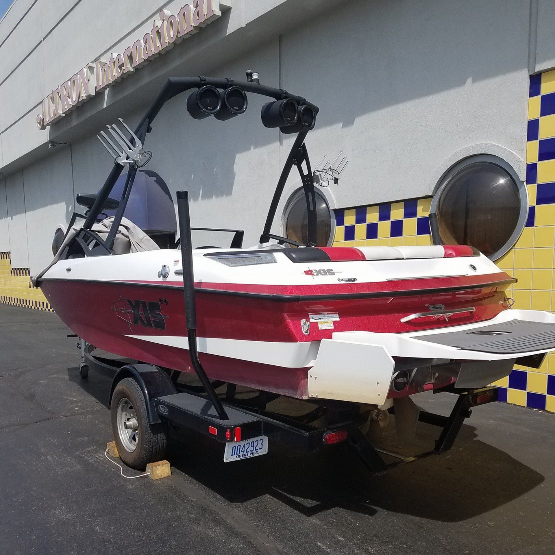 Black Harley-Davidson motorcycle with purple underglow, in a garage.