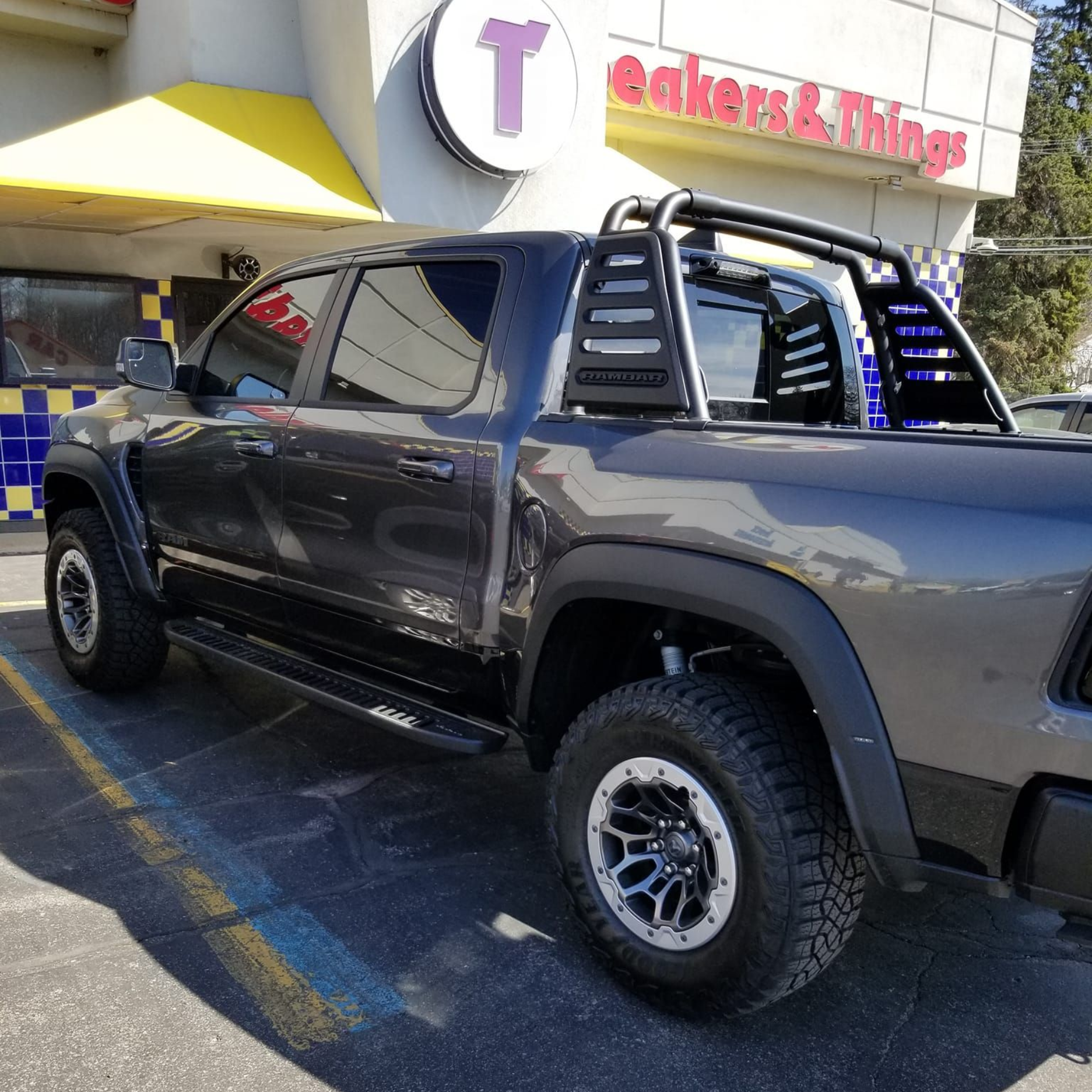 Gray pickup truck with black roll bars parked outside a 