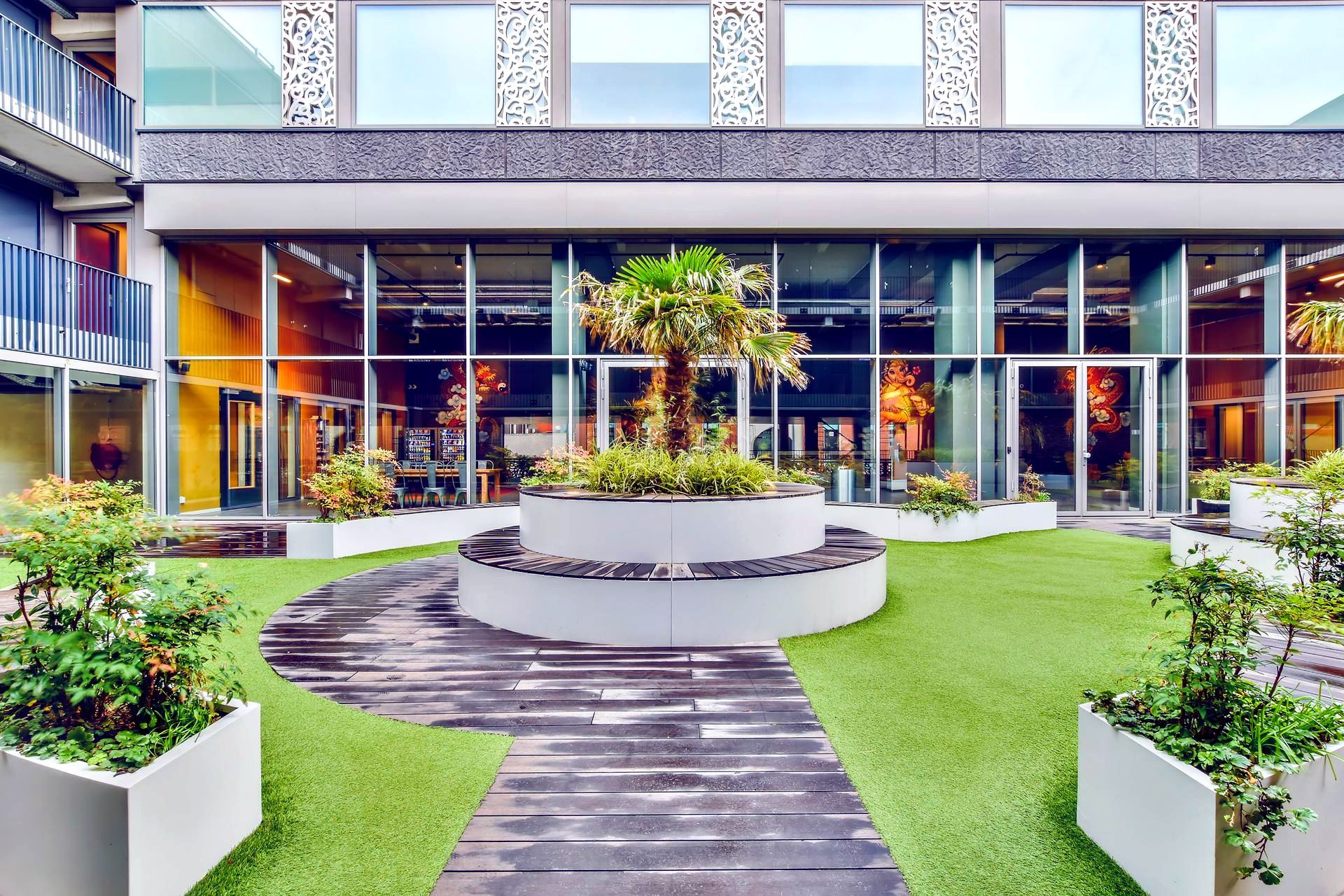 A large building with a lot of windows and a garden in front of it.