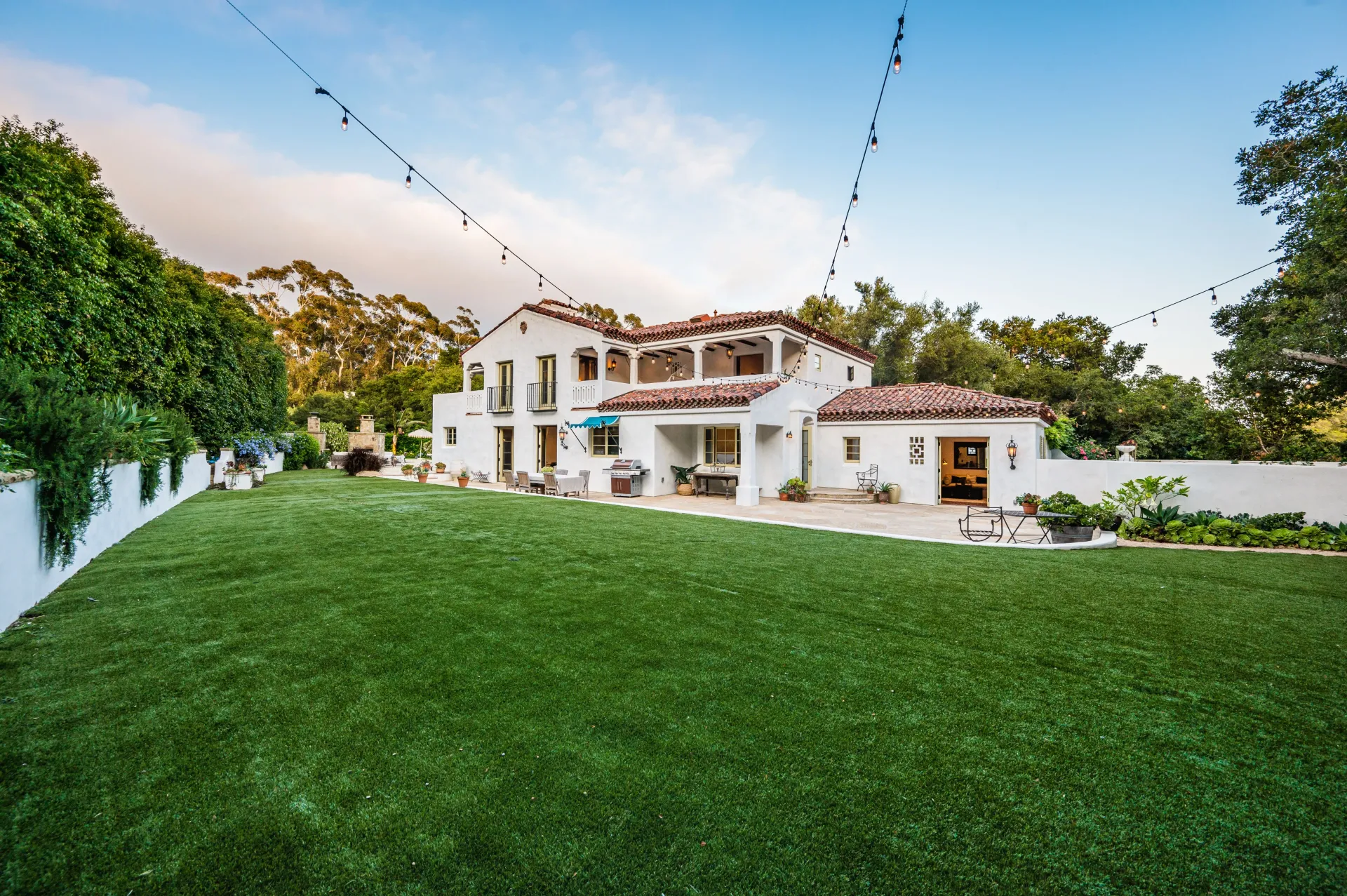 A large white house with a large lawn in front of it.