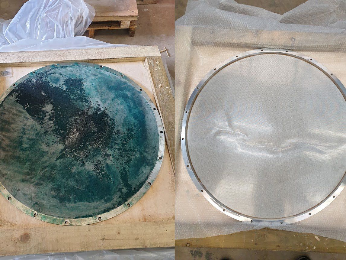 Du apvalūs objektai medinėse dėžėse, vienas atrodo patamsėjęs žaliai, kitas – sidabrinis.