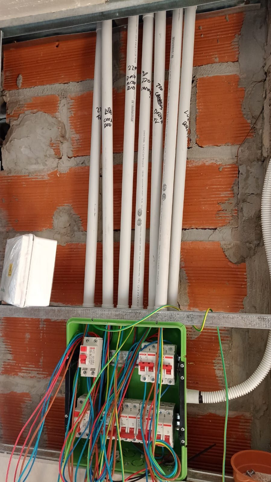 Un cerrajero está utilizando una máquina cortadora de llaves para cortar una llave sujeta en un tornillo de banco.