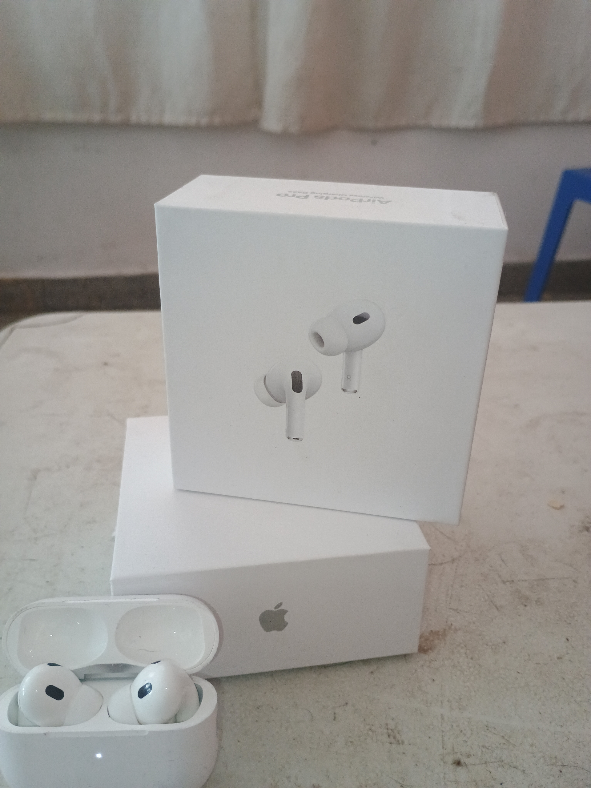 Cajas y estuche abierto de AirPods de Apple blancos sobre una superficie.