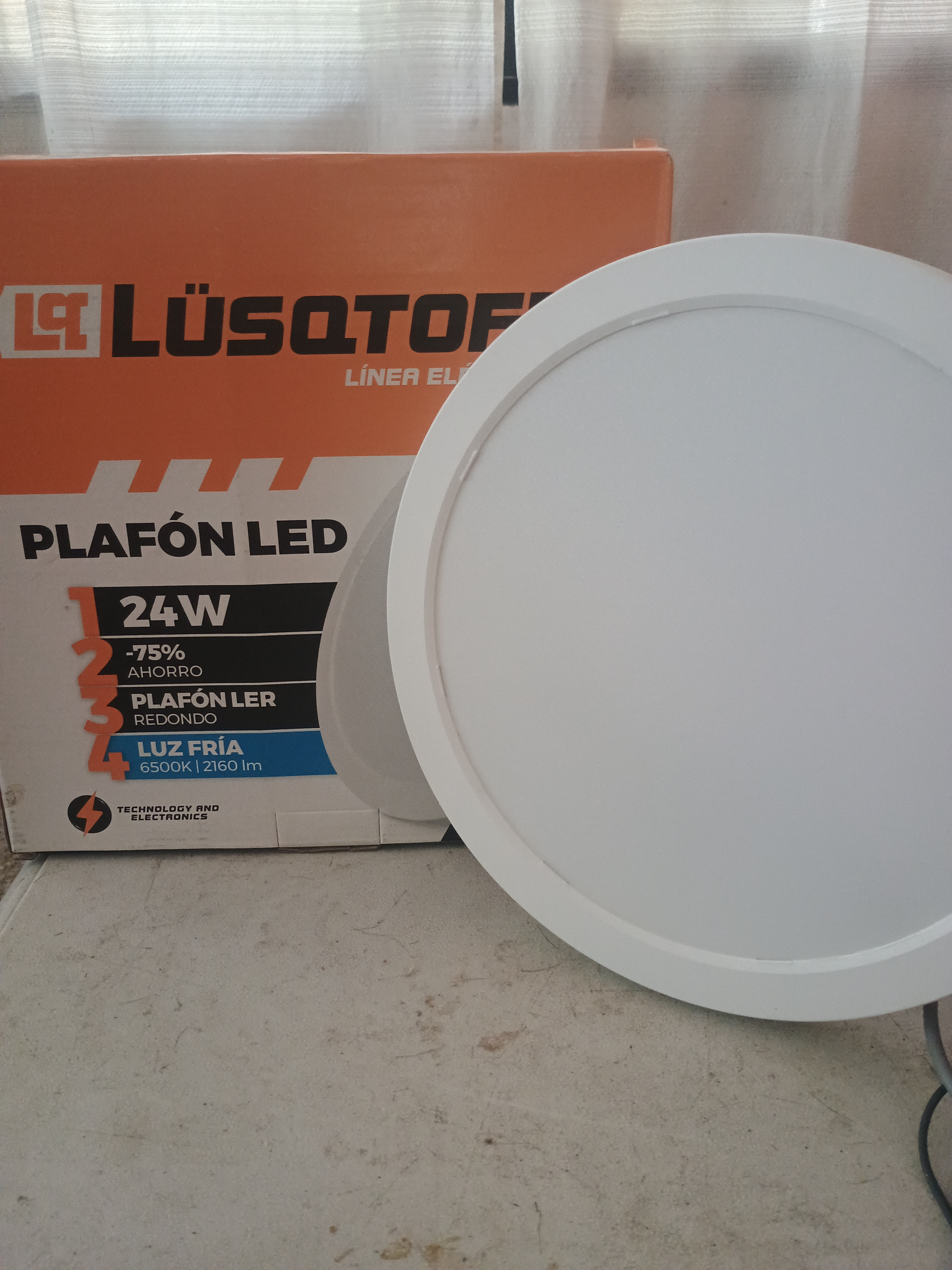 Plafón LED blanco junto a su caja naranja, rotulado “Lüsqtoff” y “Plafón LED 24W”.
