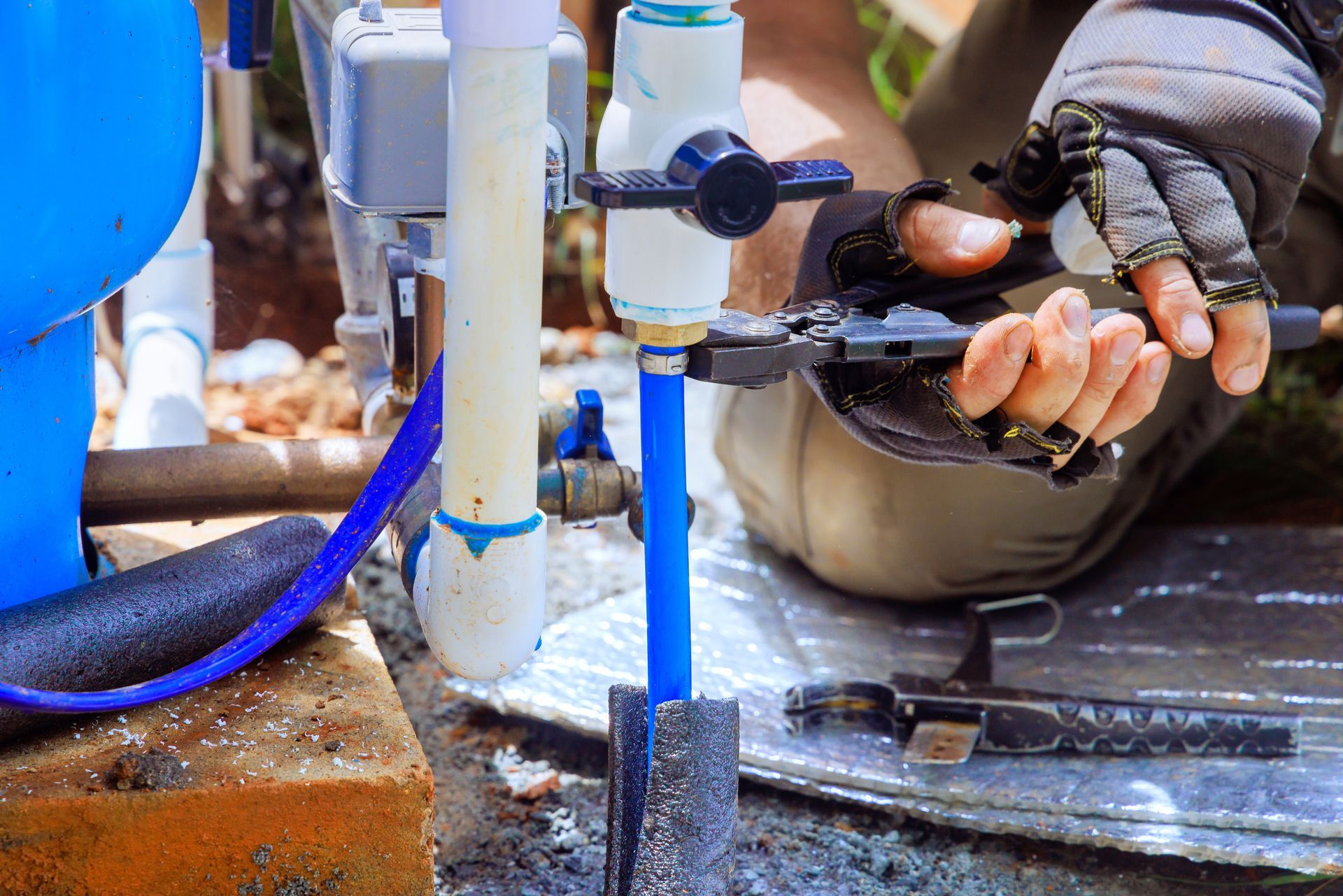 A PVC pipe is being connected to a water supply artesian well system pump house. A PVC pipe is being connected to a water supply artesian well system pump house.