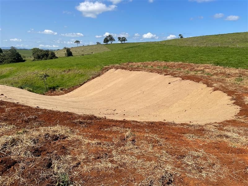 Dirt Mound in a Field, With Green Hills and Blue Sky in the Background — Macca's Dynamic Earthworks in Tolga, QLD