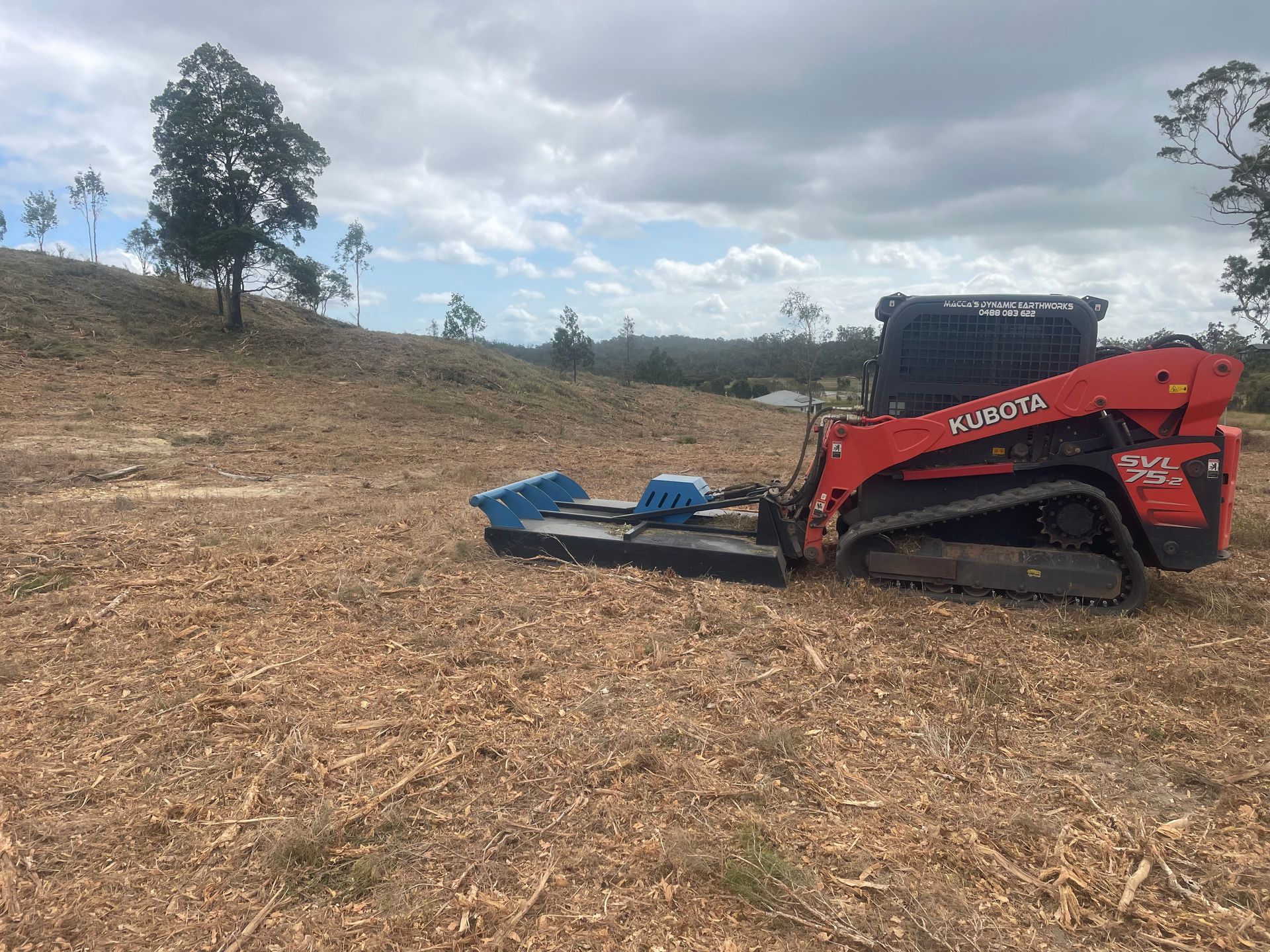 Orange Kubota Track Loader With Blue Mulcher — Macca's Dynamic Earthworks in Tolga, QLD