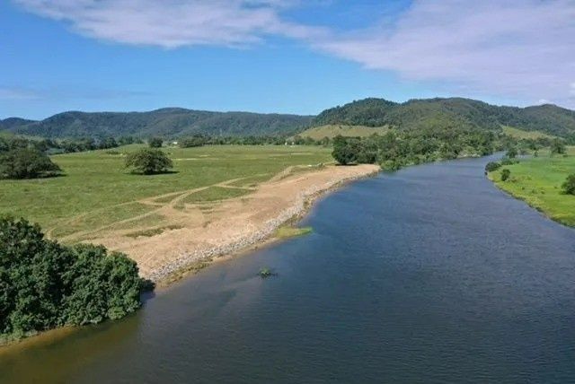 A Wide River Flows Through a Green Landscape with Trees — Macca's Dynamic Earthworks in Tolga, QLD