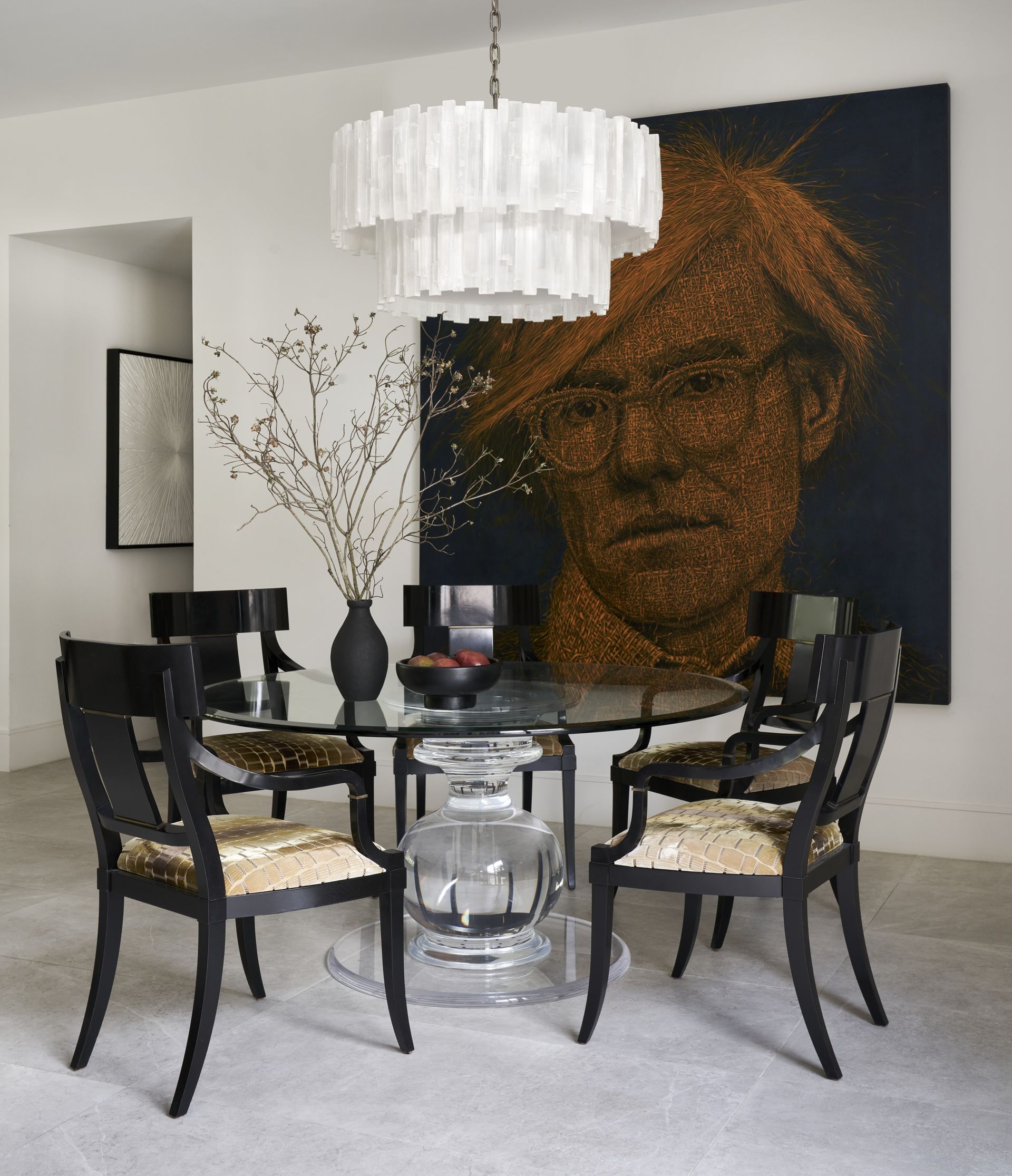 a dining room with a table and chairs and a large painting on the wall