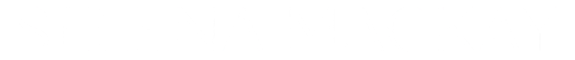 A large, vibrant, multi-colored circular floor mural with geometric patterns, set in a spacious, sunlit community building.