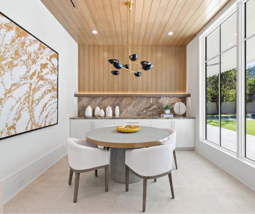 A dining room with a round table and white chairs