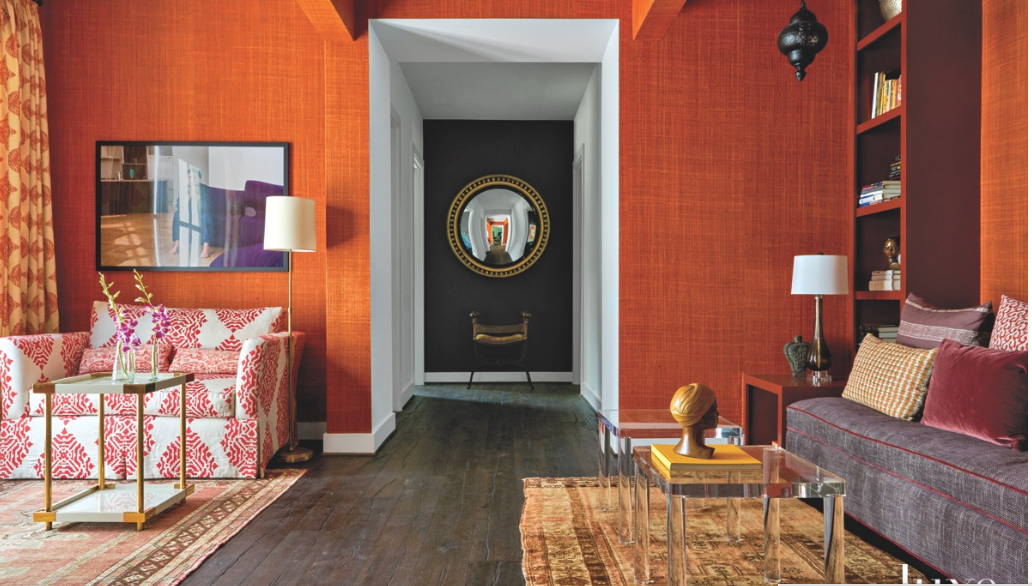 A living room with red walls and a purple couch