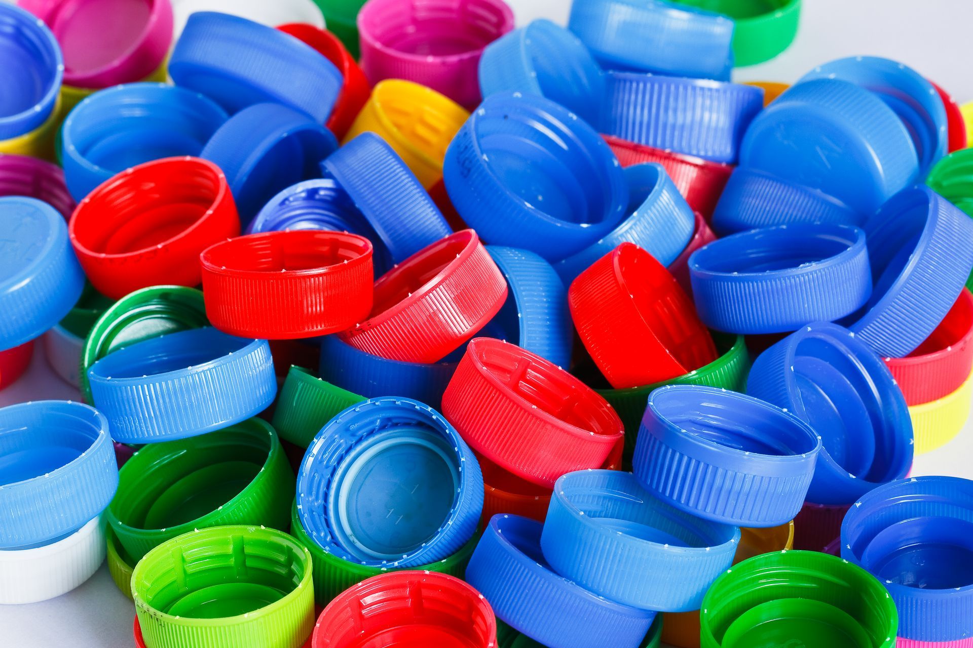 A pile of colorful plastic bottle caps on a table.