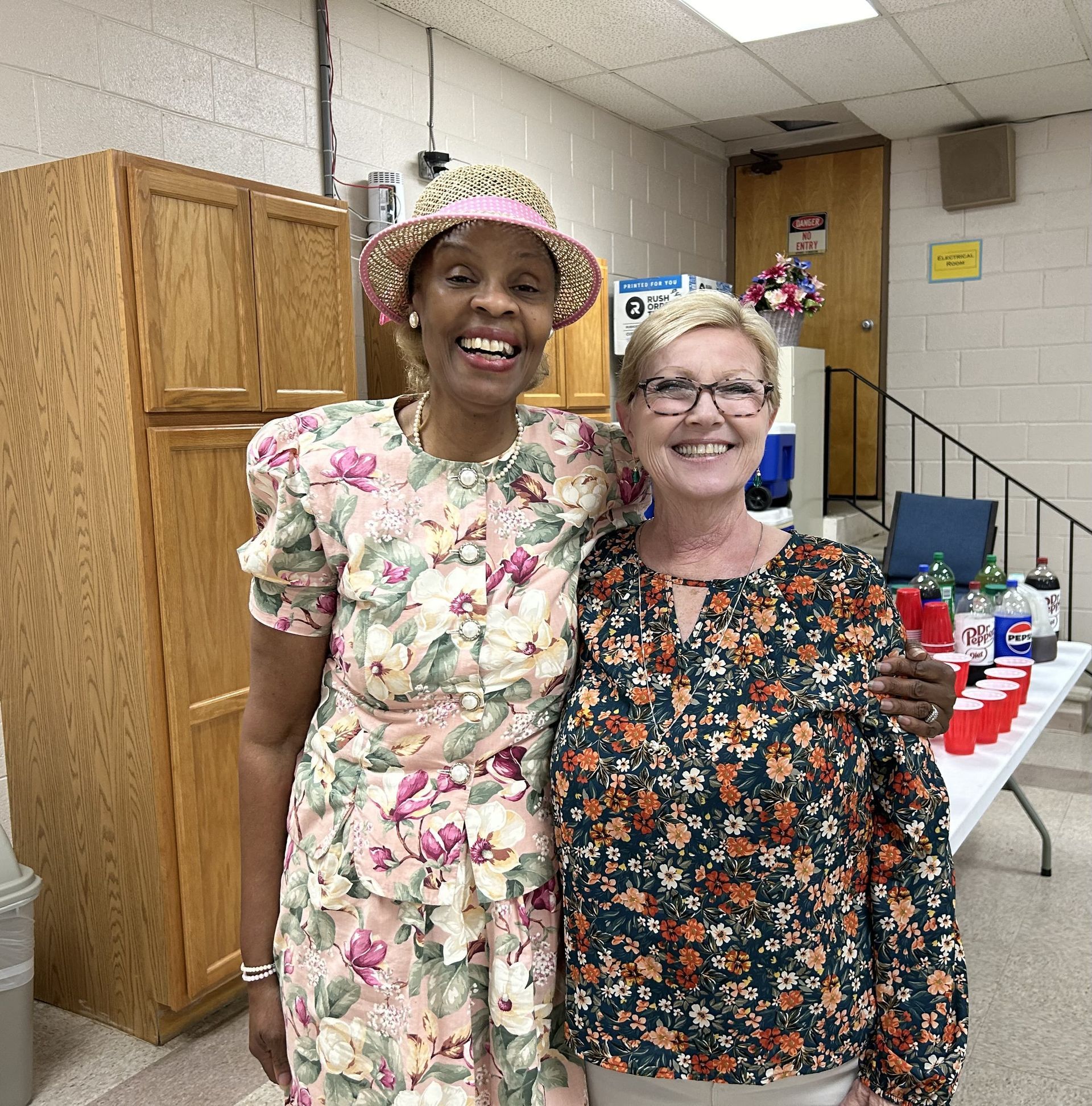 A woman wearing glasses is hugging another woman