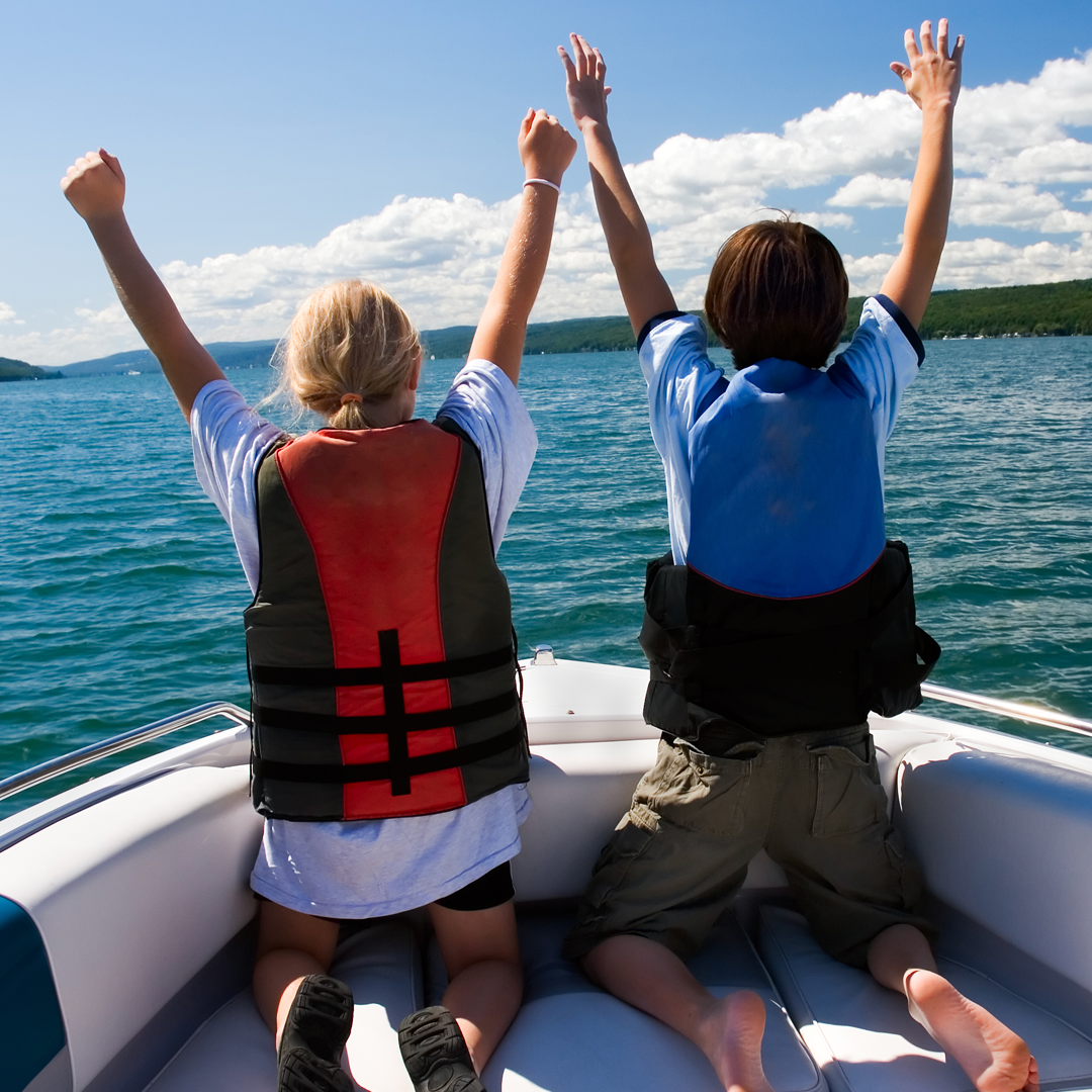 Two people on a boat with their arms in the air