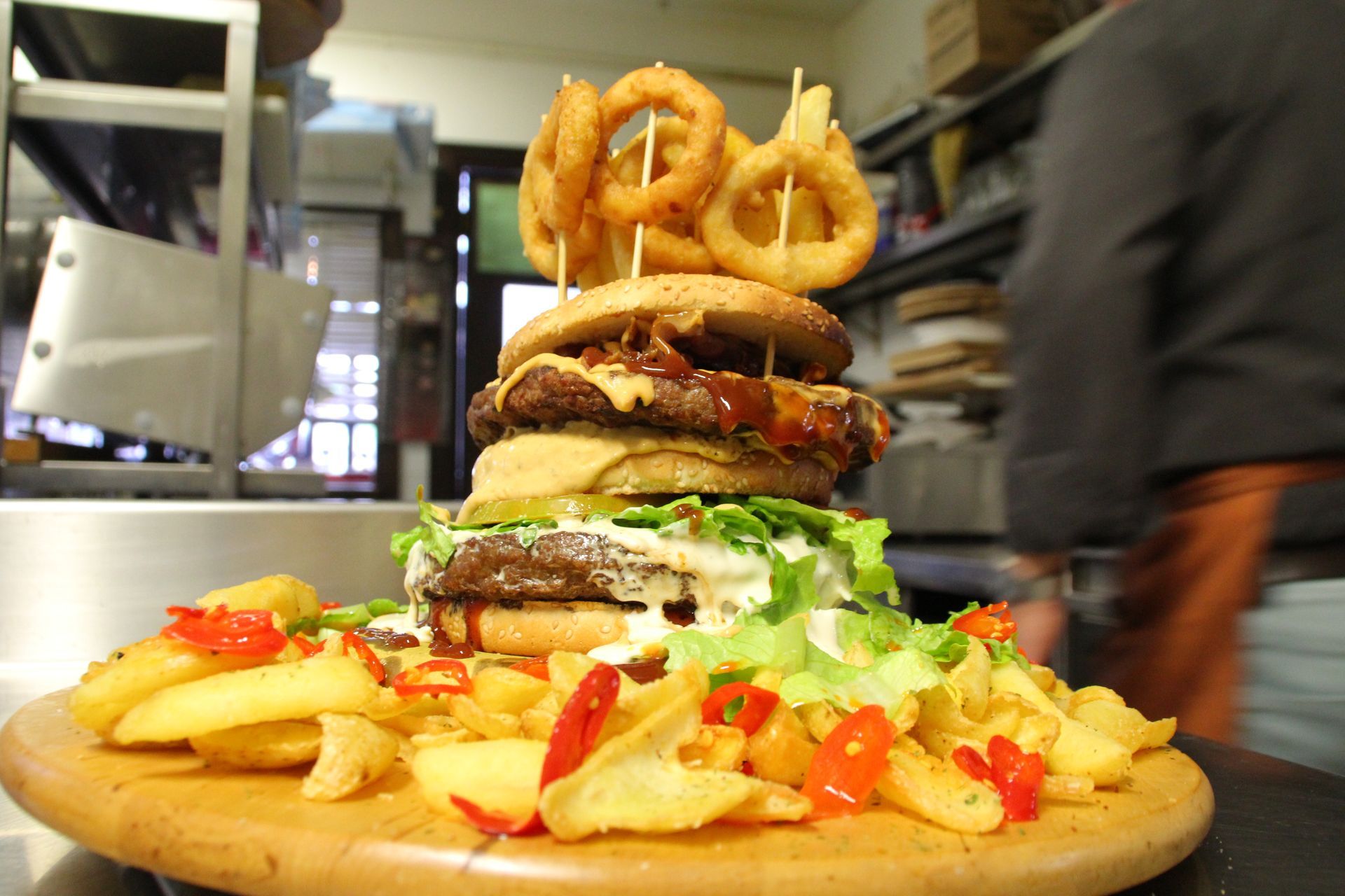 Hamburger gigante con anelli di cipolla e patatine fritte