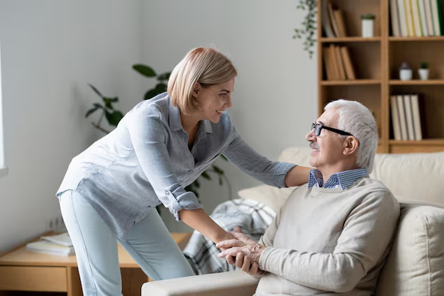 Woman assisting an elderly person seated on a couch.