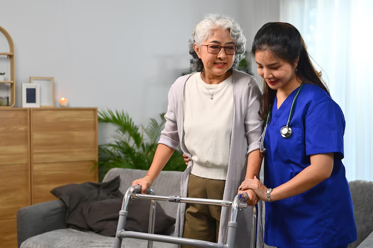 Caregiver assisting an older person with a walker in a home setting.