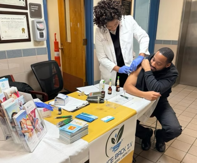 A man is getting an injection from a female doctor