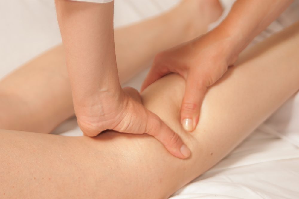 A woman is getting a massage on her leg.