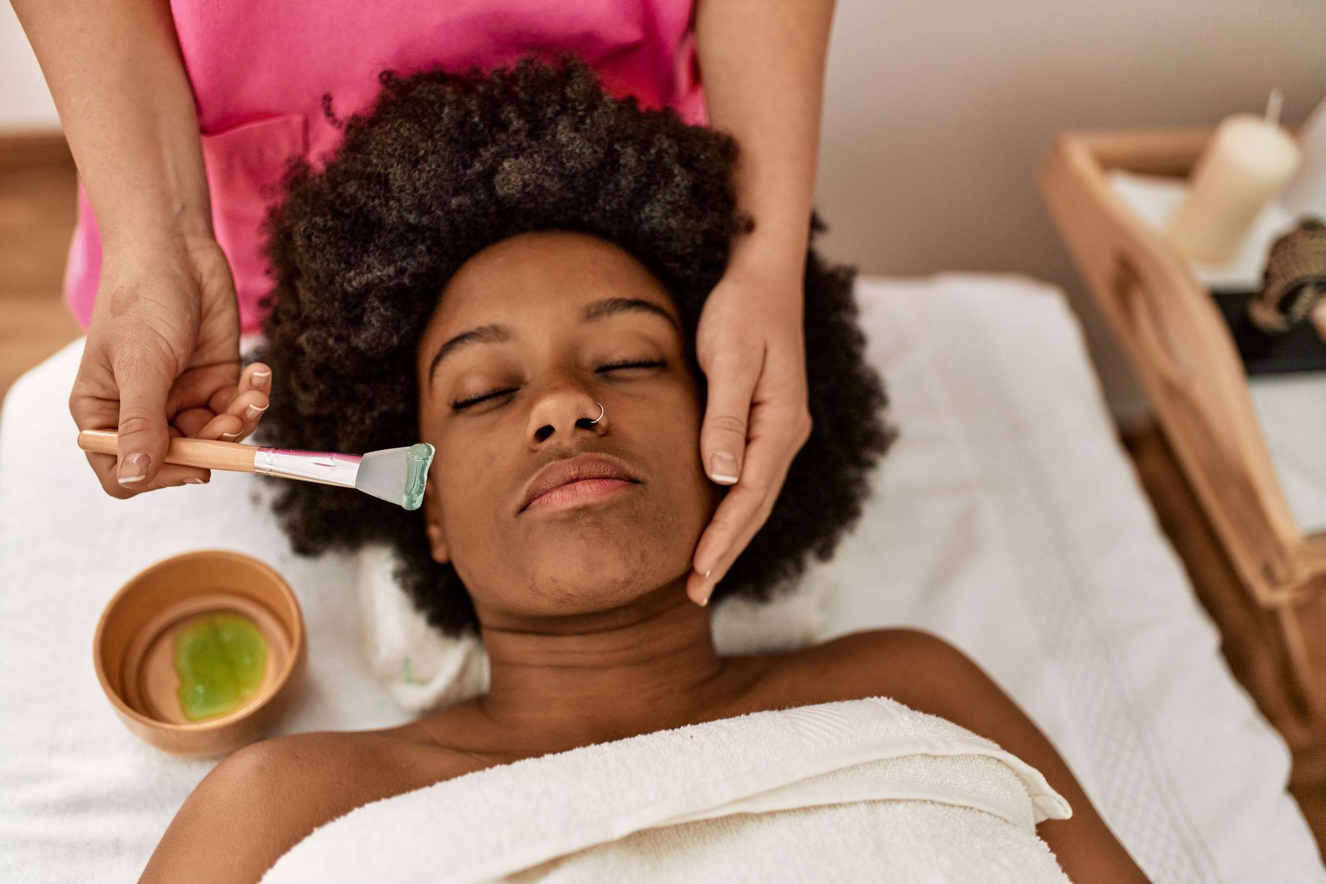 A woman is getting a facial treatment at a spa.