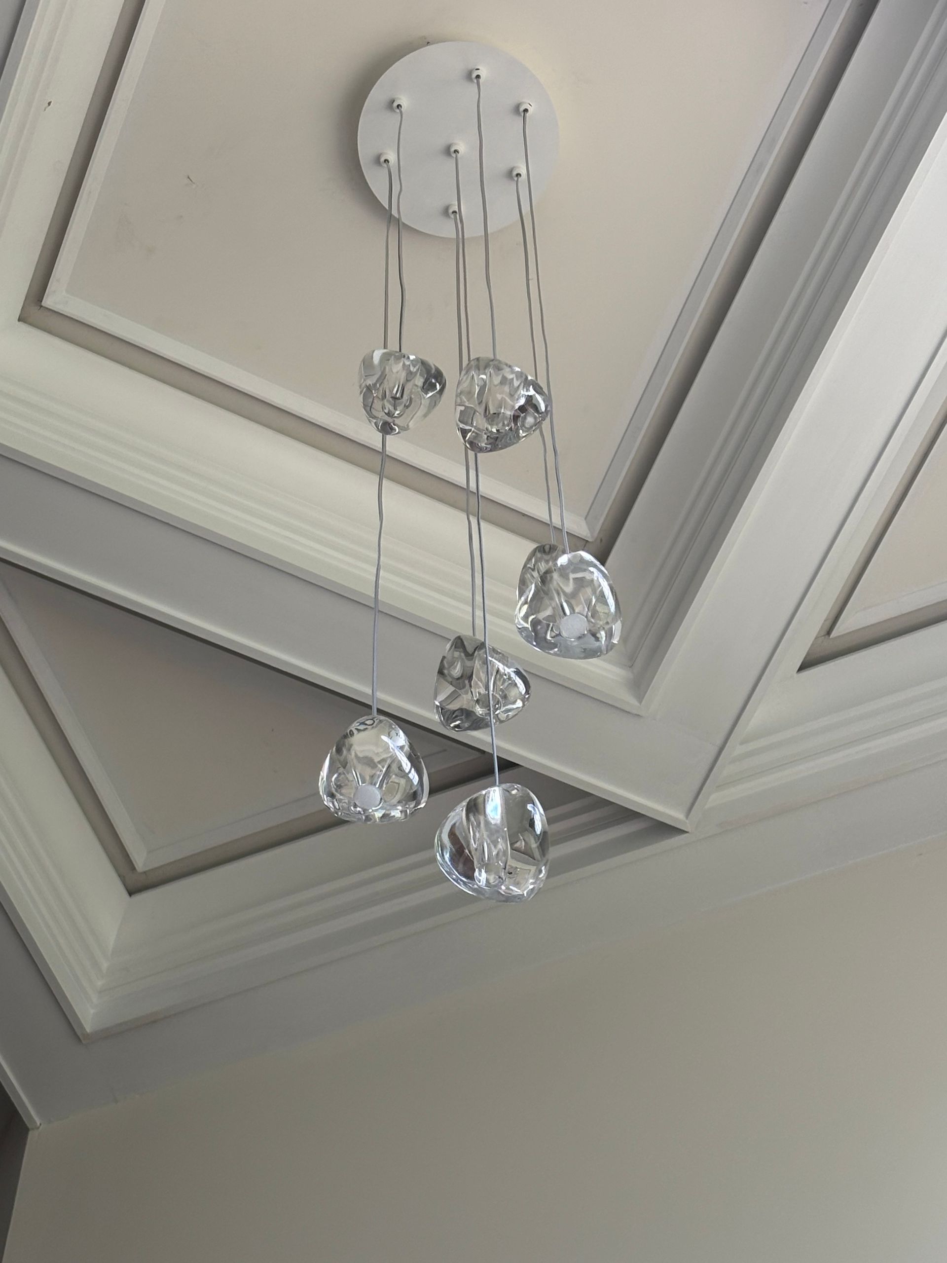 Person installing an electrical outlet, holding it with wires attached and using a screwdriver.
