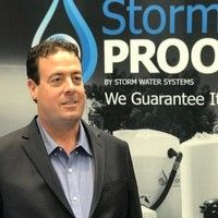 Man standing at a trade show booth with a Storm PROOF banner and stormwater systems display