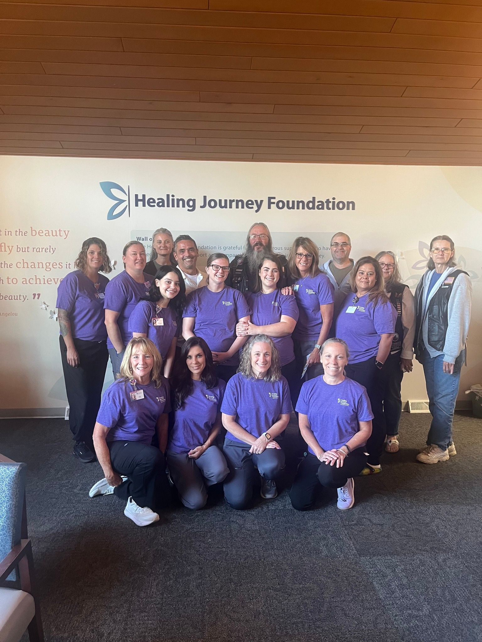 Group of people in purple shirts posing in front of 