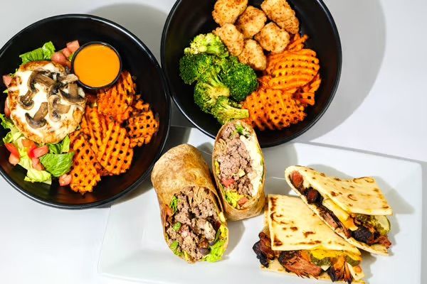 Woman assisting another woman getting into a car; outside a brick building.