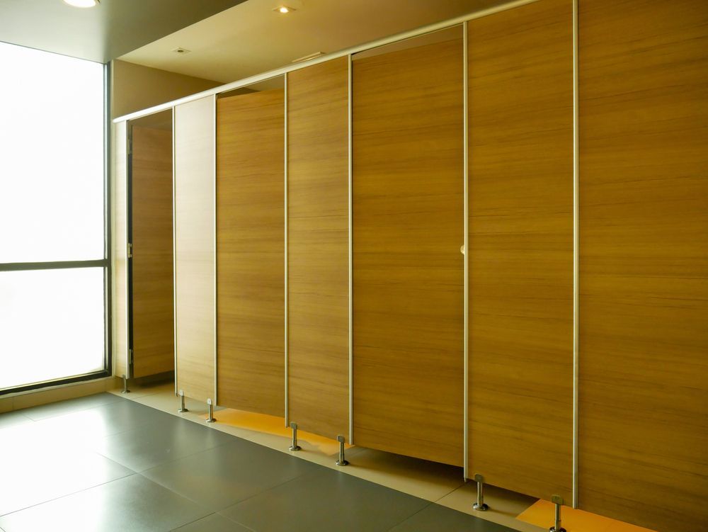 A row of wooden toilet cubicles in a public restroom.