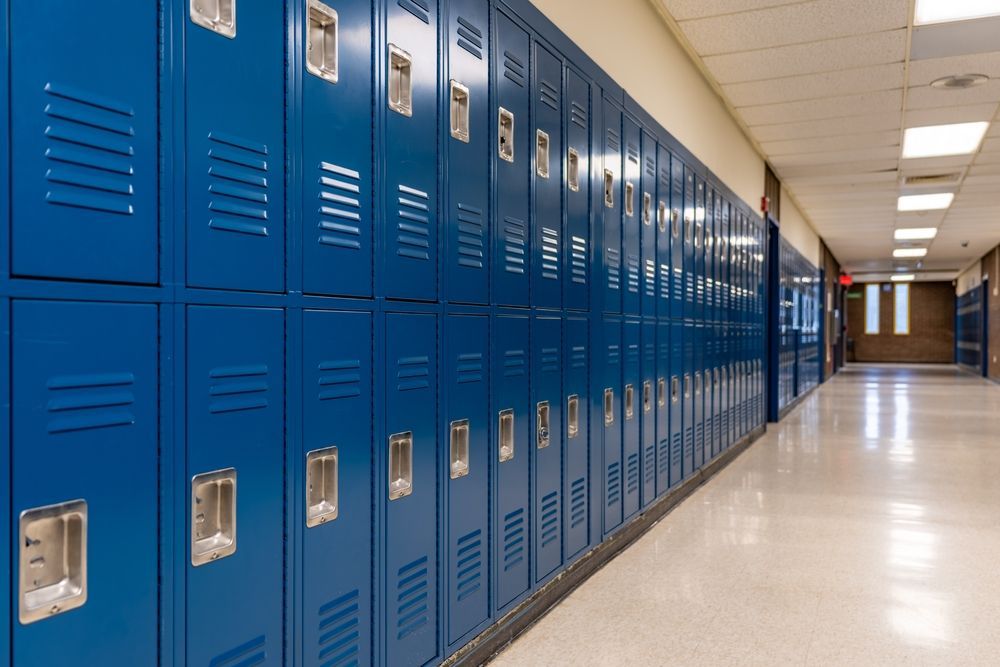 A long hallway filled with blue lockers in a school.