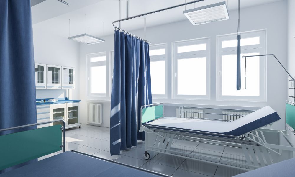 A hospital room with a bed and a blue curtain.