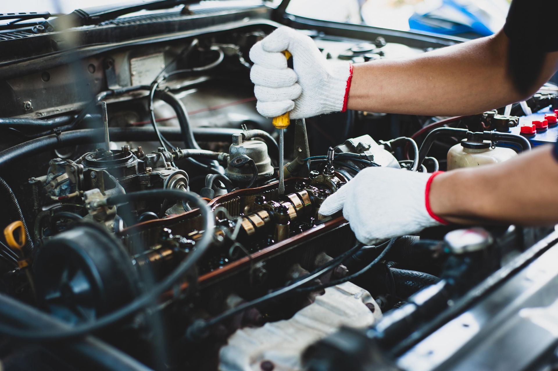 Mechanic using a wrench to repair a car engine in a workshop