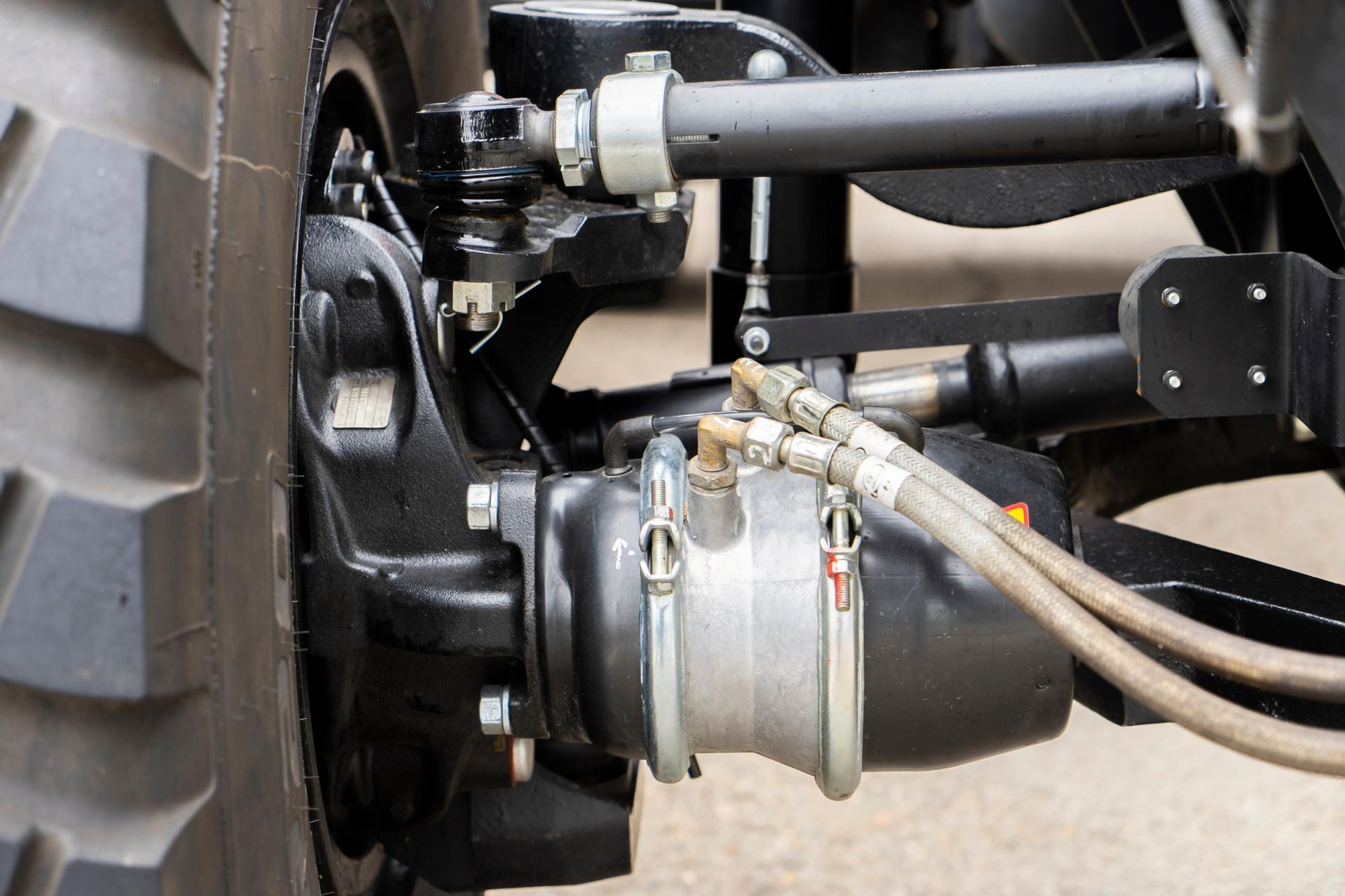 Close-up of a vehicle wheel hub with connected hoses and metal suspension parts.