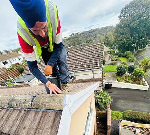 A man is working on the roof of a house.