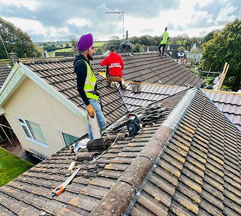 A group of men are working on the roof of a house.