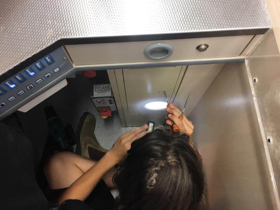 Woman is Looking Under a Cabinet With a Flashlight — KeyBay in Bowral, NSW