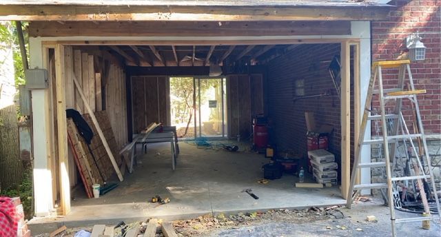 A garage is being remodeled with a ladder and a table.