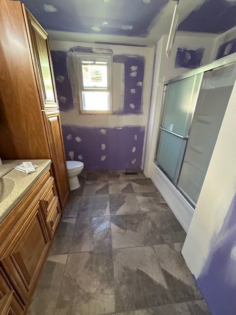 A bathroom with a toilet , sink , and shower.
