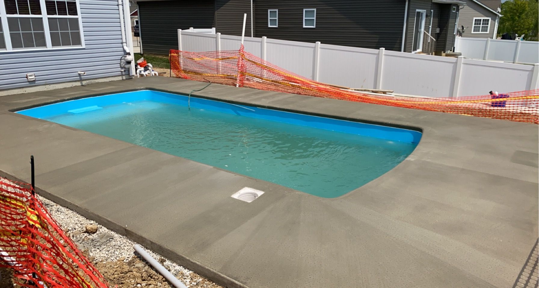 A swimming pool is being built in the backyard of a house.