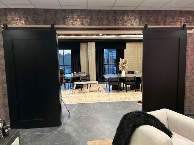 A living room with sliding barn doors leading to a dining room.