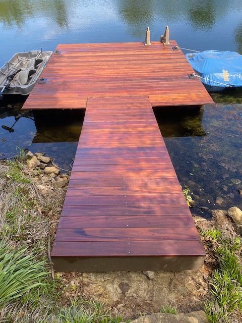 A wooden dock is sitting next to a body of water.