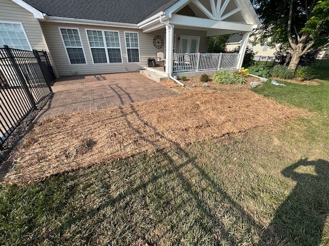 A house with a fence and a lot of dirt in front of it