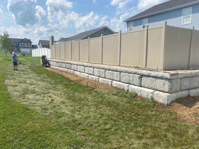 A fence is being built in the backyard of a house.