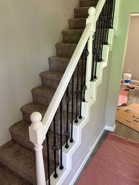 A staircase with carpeted steps and a white railing