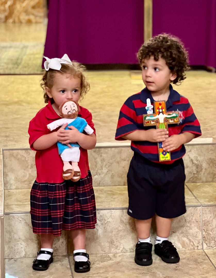 A boy and a girl standing next to each other holding toys
