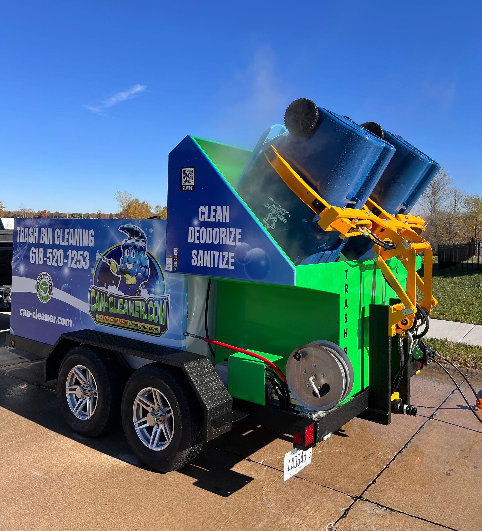 Two green garbage cans are sitting on top of a blue dumpster.