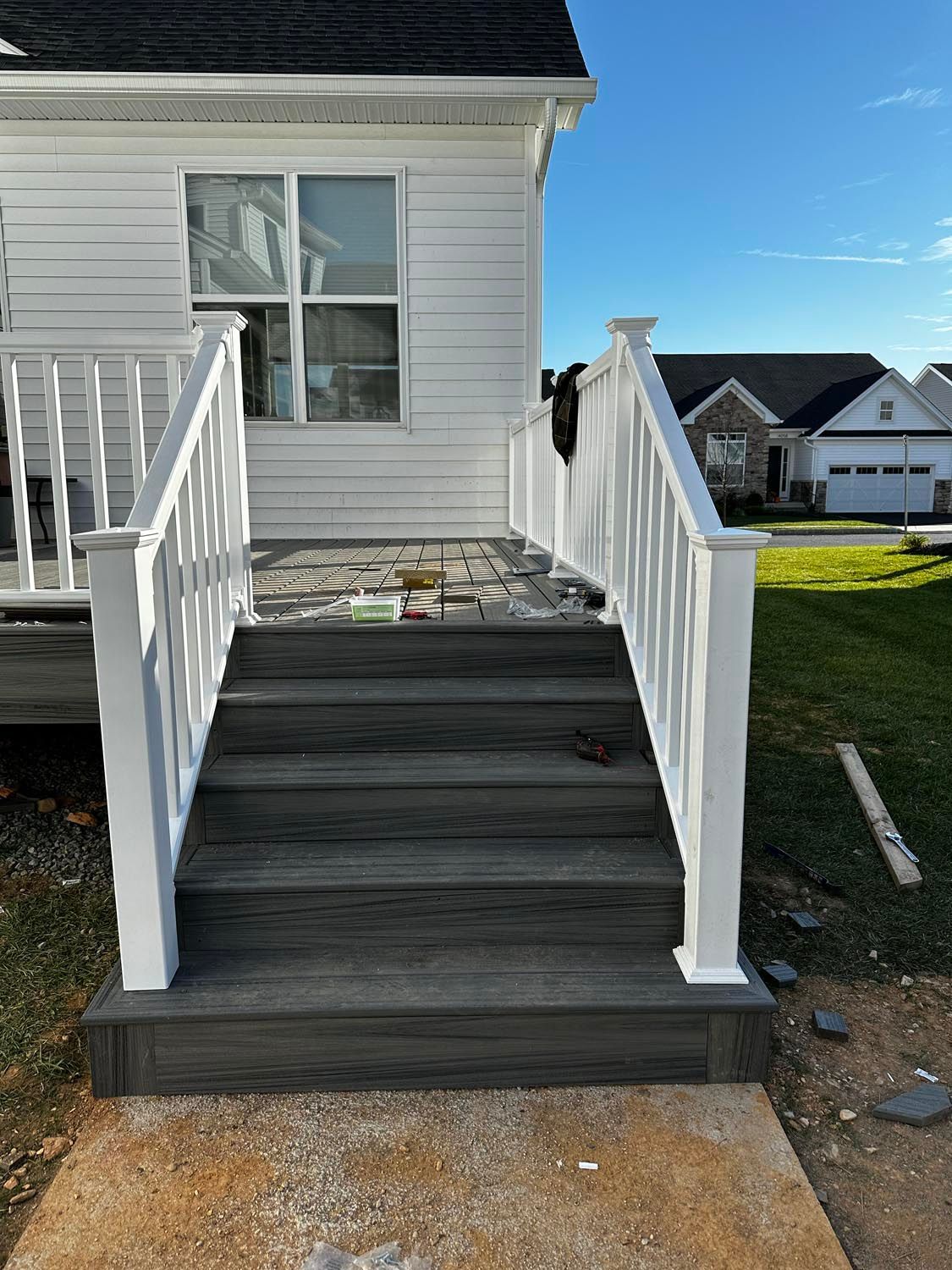 A white house with stairs leading up to it and a white railing.