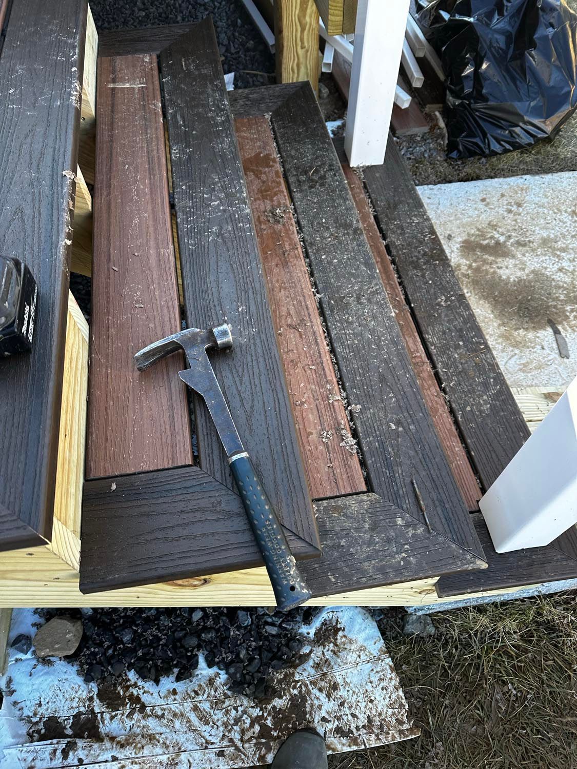 A hammer is sitting on top of a piece of wood.